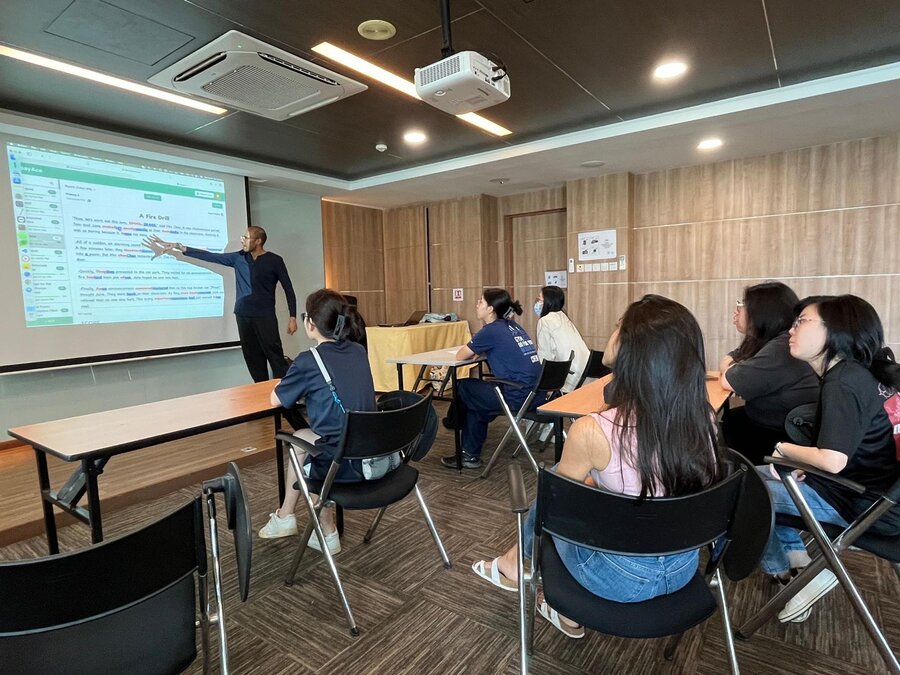 Yew Tee CC YouthThink session – students watching EssayAce.AI essay feedback on projector